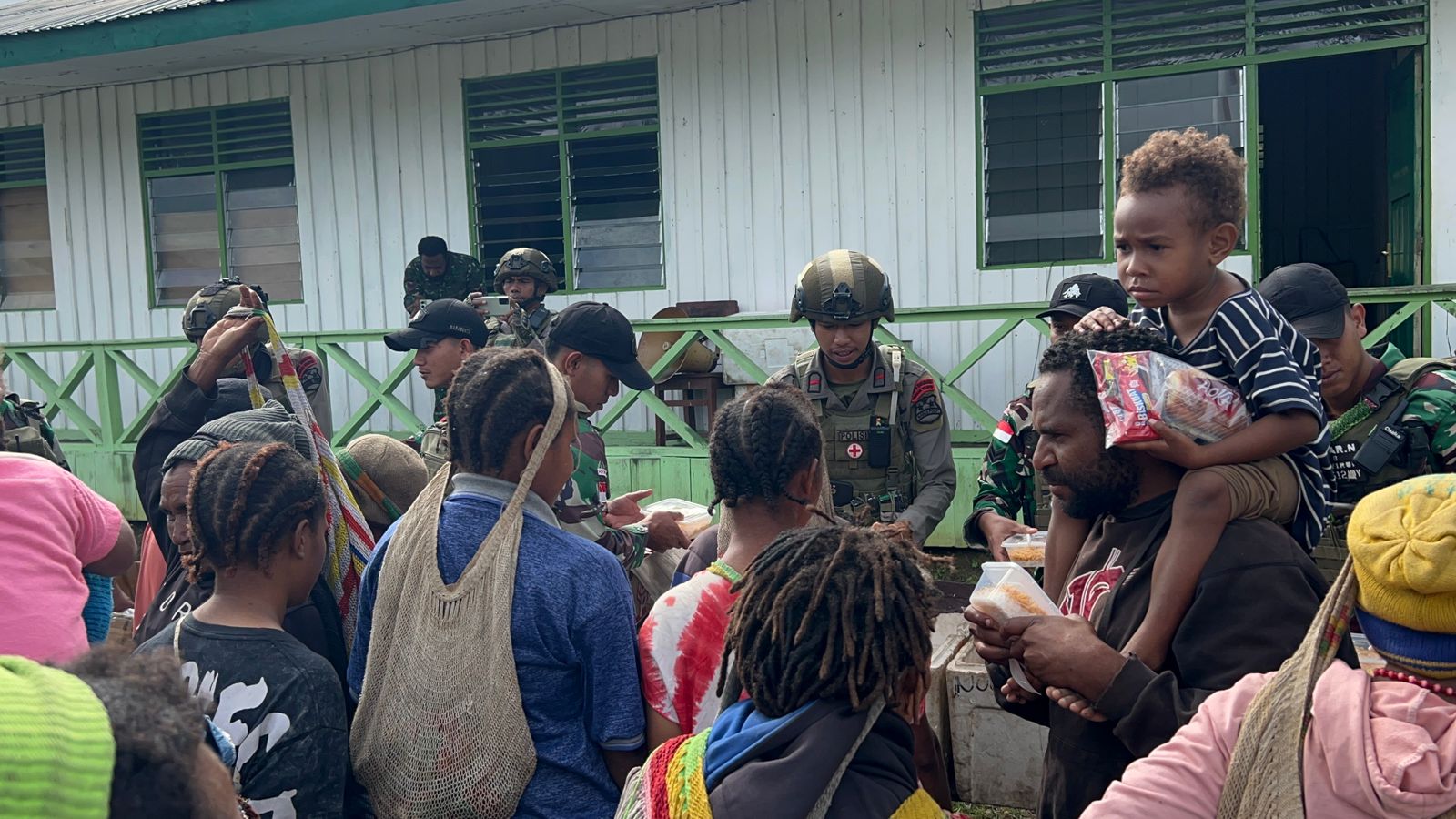 aparat gabungan membagikan sembako kepada masyarakat